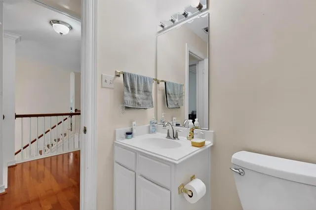 a bathroom with a sink mirror vanity and toilet