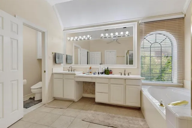 a spacious bathroom with a granite countertop sink mirror and a bathtub