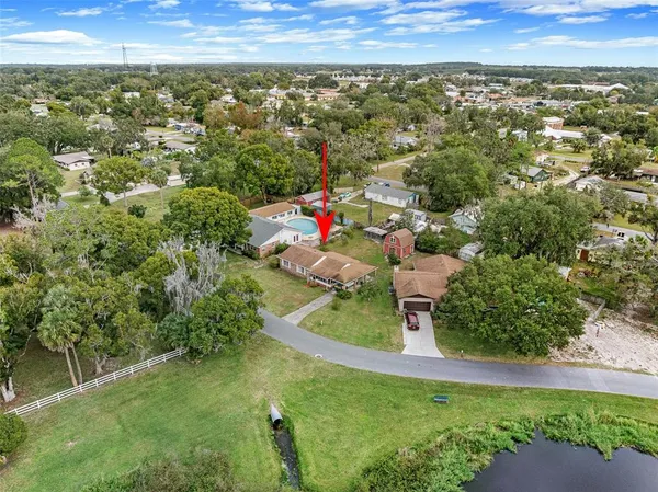 an aerial view of residential houses with outdoor space and trees