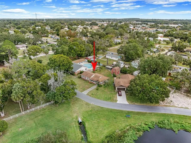 an aerial view of residential houses with outdoor space and trees