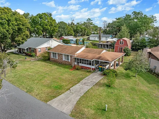 an aerial view of residential houses with yard and trees