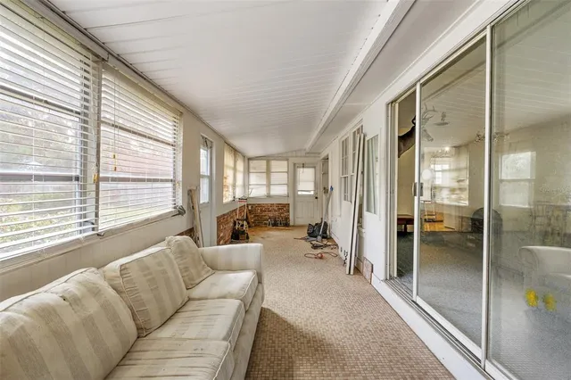 a view of an empty room with a chandelier fan
