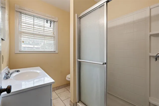 an aerial view of residential houses with outdoor space and trees