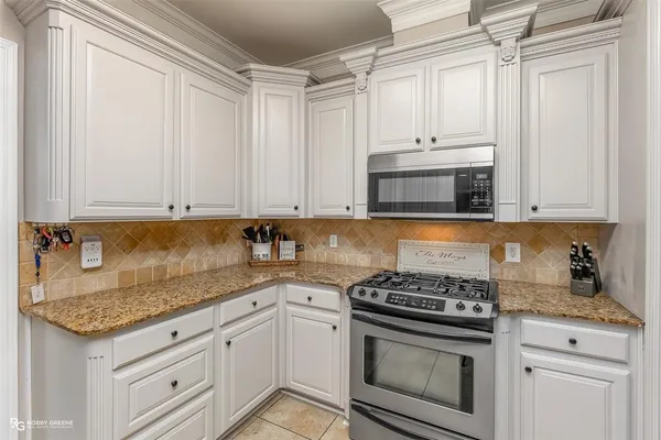a kitchen with granite countertop a sink stainless steel appliances and cabinets