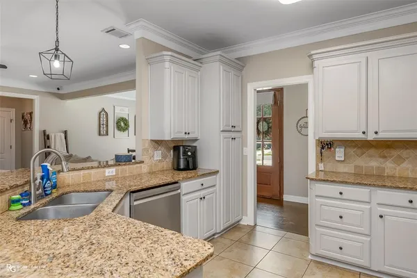 a kitchen with granite countertop a sink stove and refrigerator