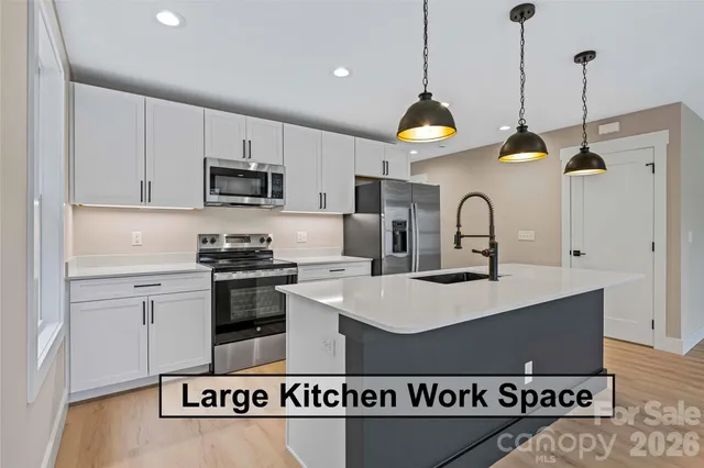 a kitchen with stainless steel appliances granite countertop a sink a stove a refrigerator and cabinets