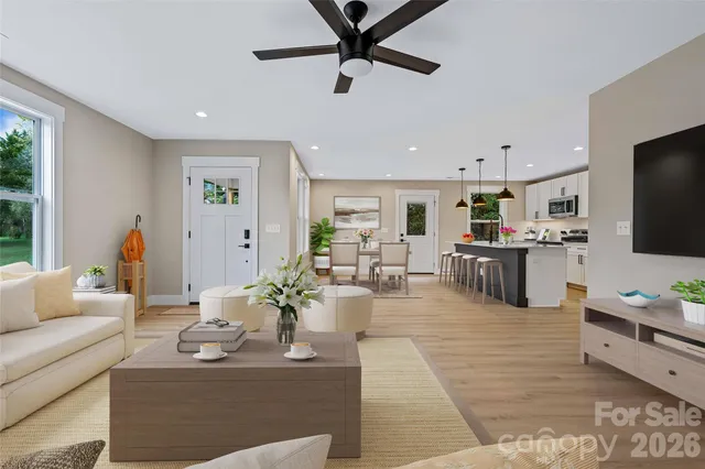 a living room with furniture kitchen view and a window