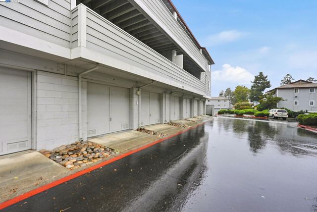 a view of a patio with table and chairs potted plants with floor to ceiling window and potted plants