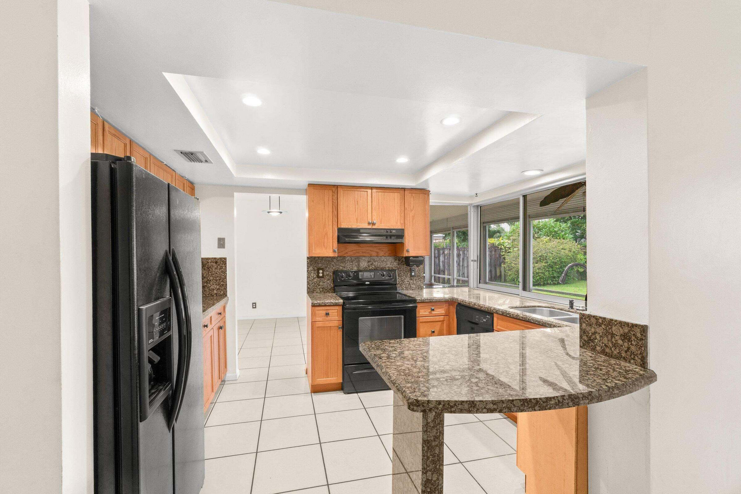 921 Southwest 11th Terrace Boca Raton, FL 33486 - Photo 3 of 26 a kitchen with stainless steel appliances granite countertop a refrigerator and a sink