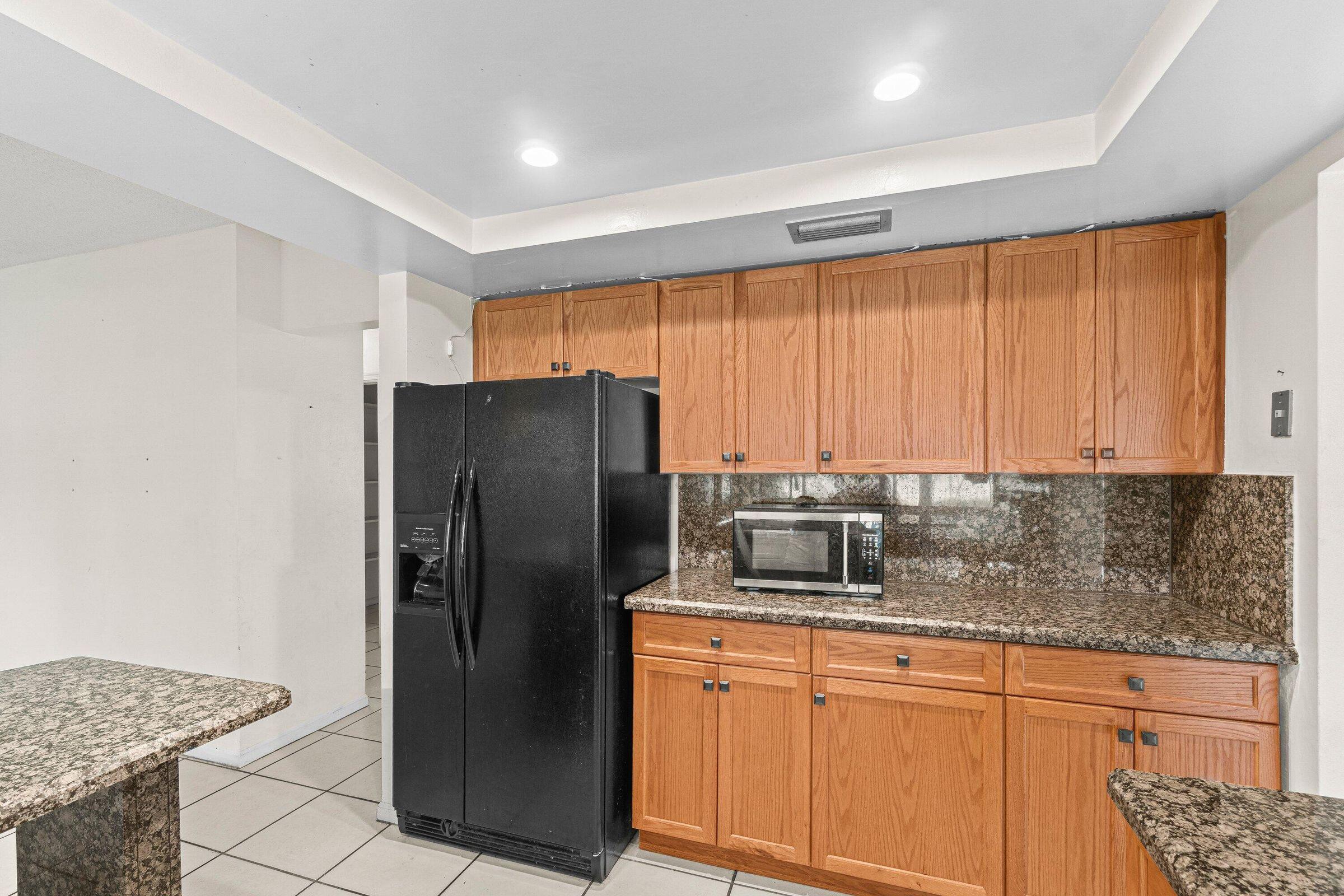 921 Southwest 11th Terrace Boca Raton, FL 33486 - Photo 5 of 26 a kitchen with stainless steel appliances granite countertop a refrigerator and a sink