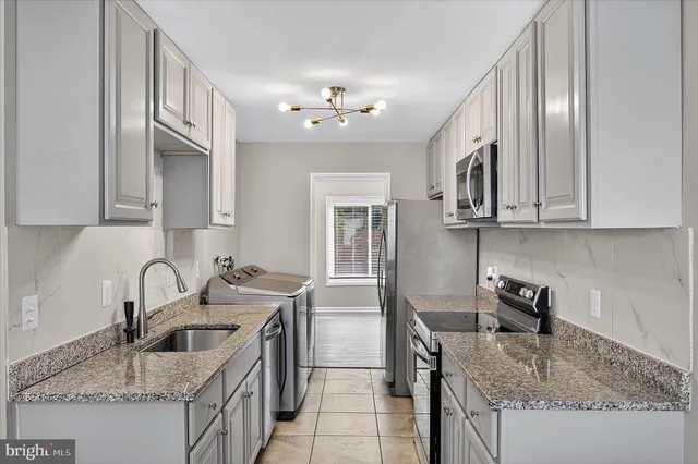 a kitchen with stainless steel appliances granite countertop a sink stove and cabinets
