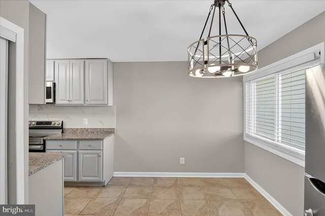 a kitchen with a chandelier and cabinets