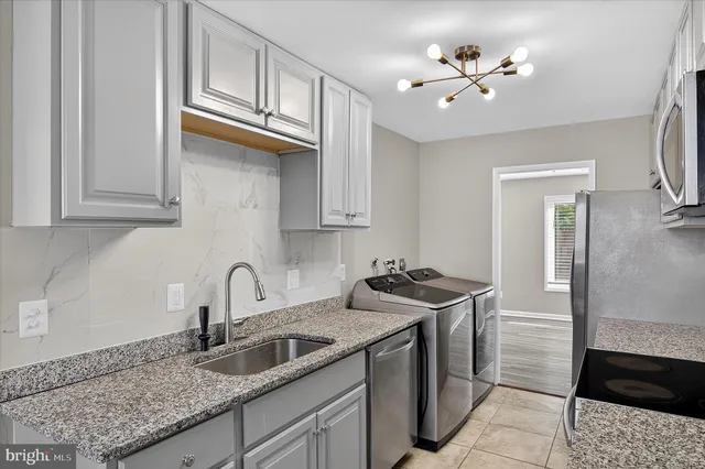 a kitchen with stainless steel appliances granite countertop a sink a stove and cabinets