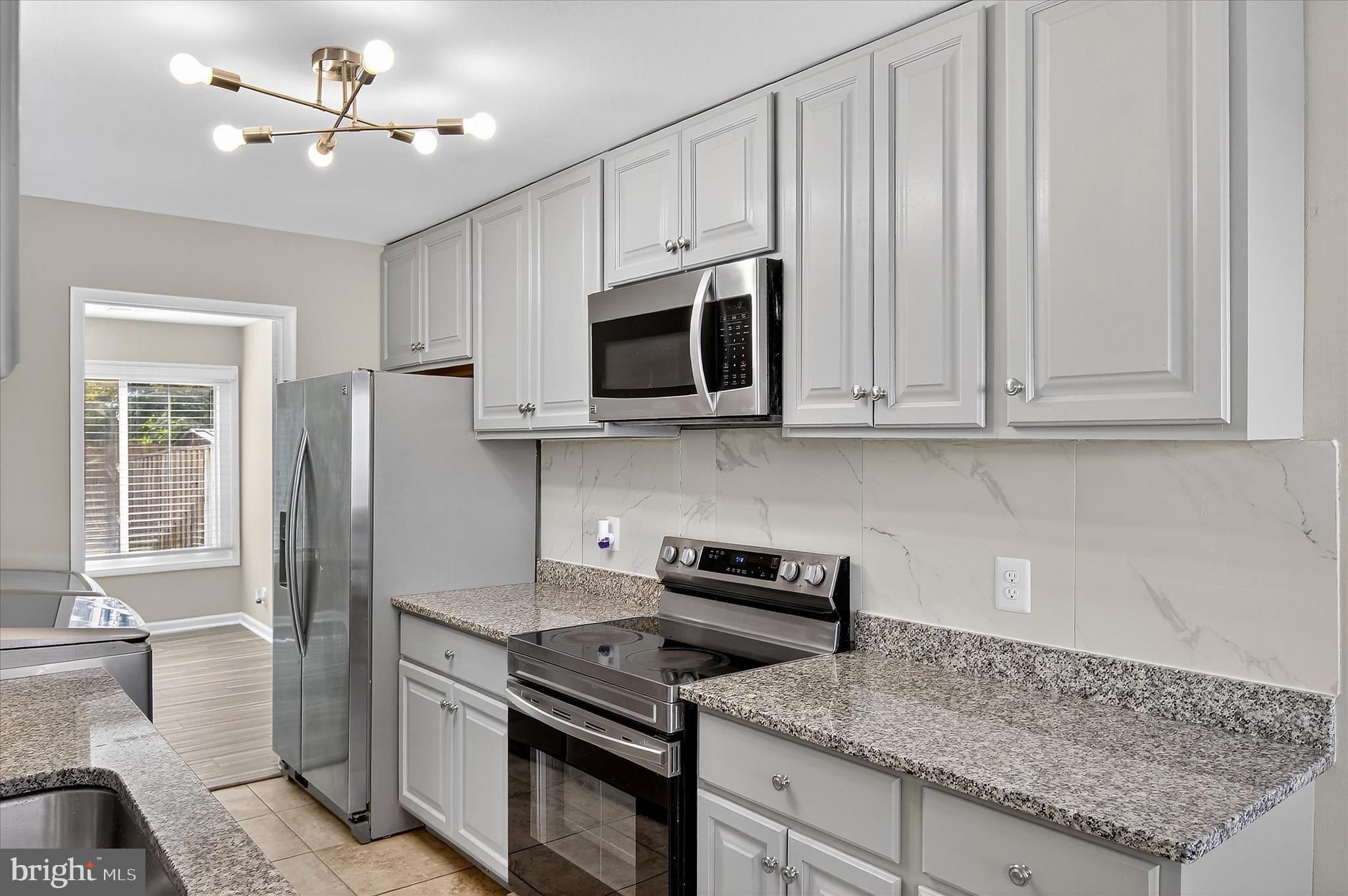 402 Reneau Way Herndon, VA 20170 - Photo 31 of 31 a kitchen with stainless steel appliances granite countertop a stove a microwave and a refrigerator