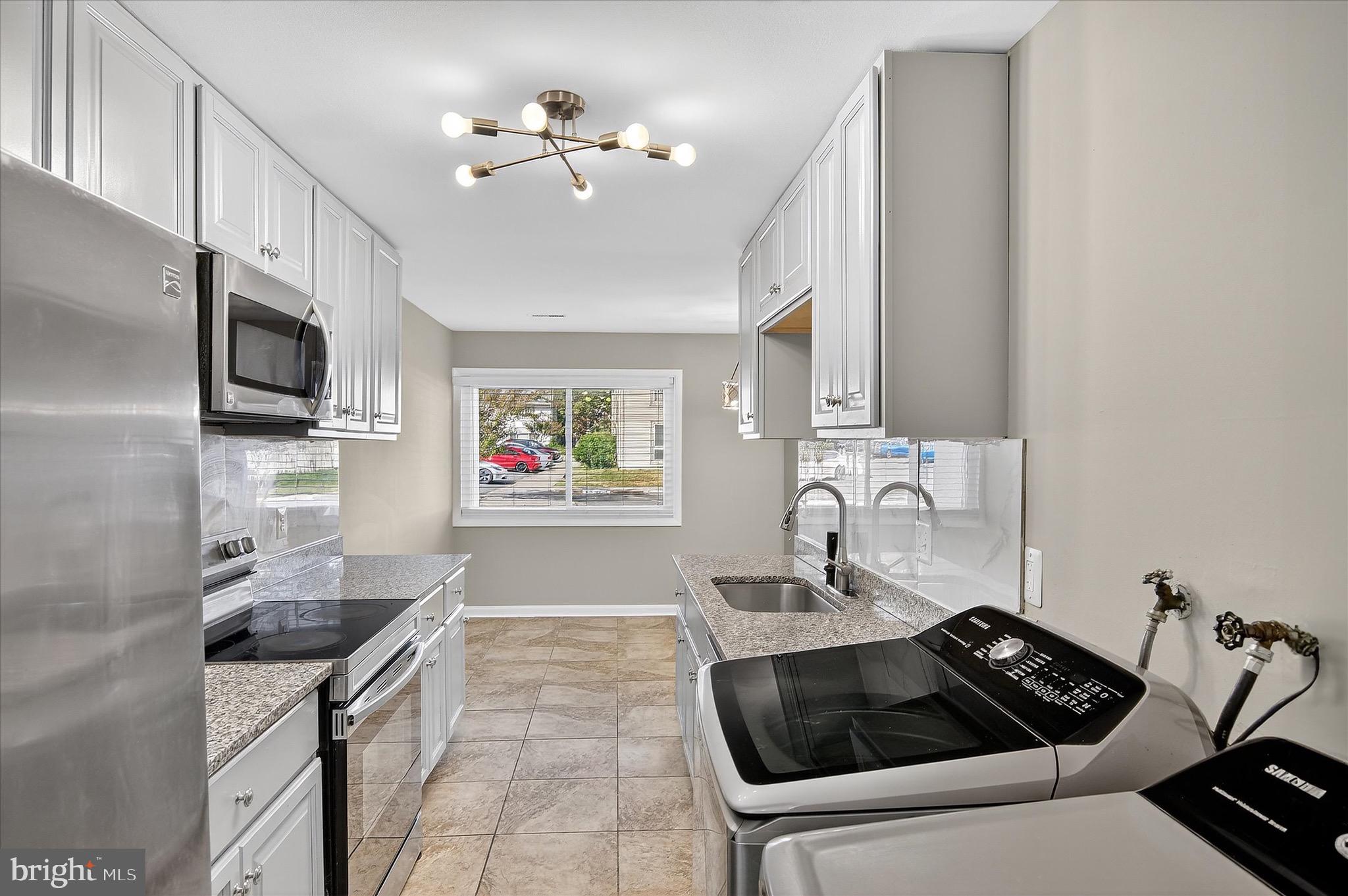 402 Reneau Way Herndon, VA 20170 - Photo 9 of 31 a kitchen with granite countertop a sink stove and cabinets