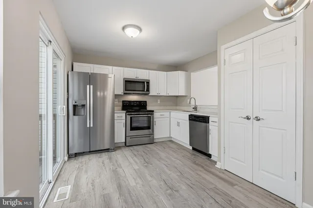 a view of empty room with wooden floor and window