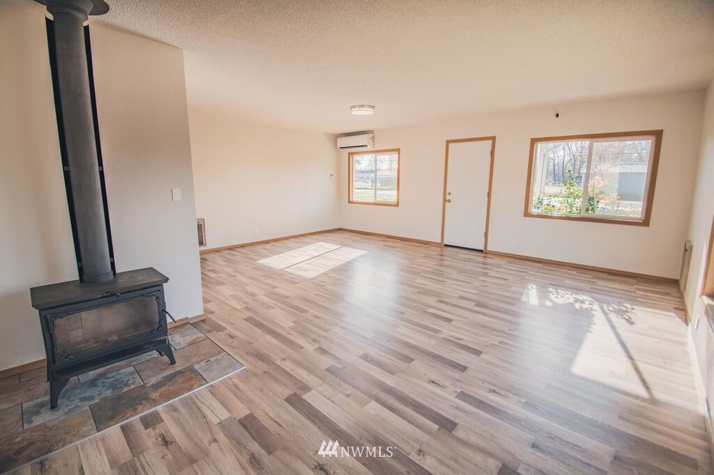 8414 183rd Avenue Southwest Rochester, WA 98579 - Photo 7 of 19 a view of an empty room with wooden floor and a window