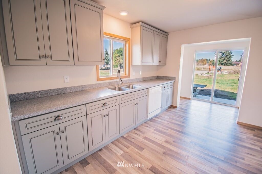 8414 183rd Avenue Southwest Rochester, WA 98579 - Photo 8 of 19 a kitchen with sink cabinets and wooden floor