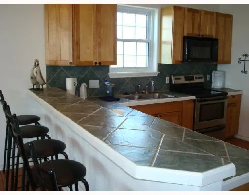 a kitchen with granite countertop a stove a sink and a microwave