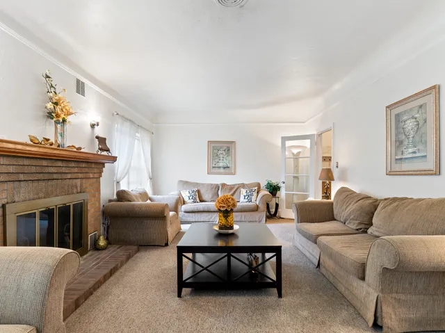 a living room with furniture a fireplace and a table