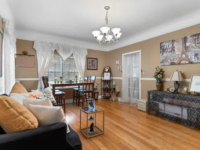 a living room with furniture a dining table and a chandelier