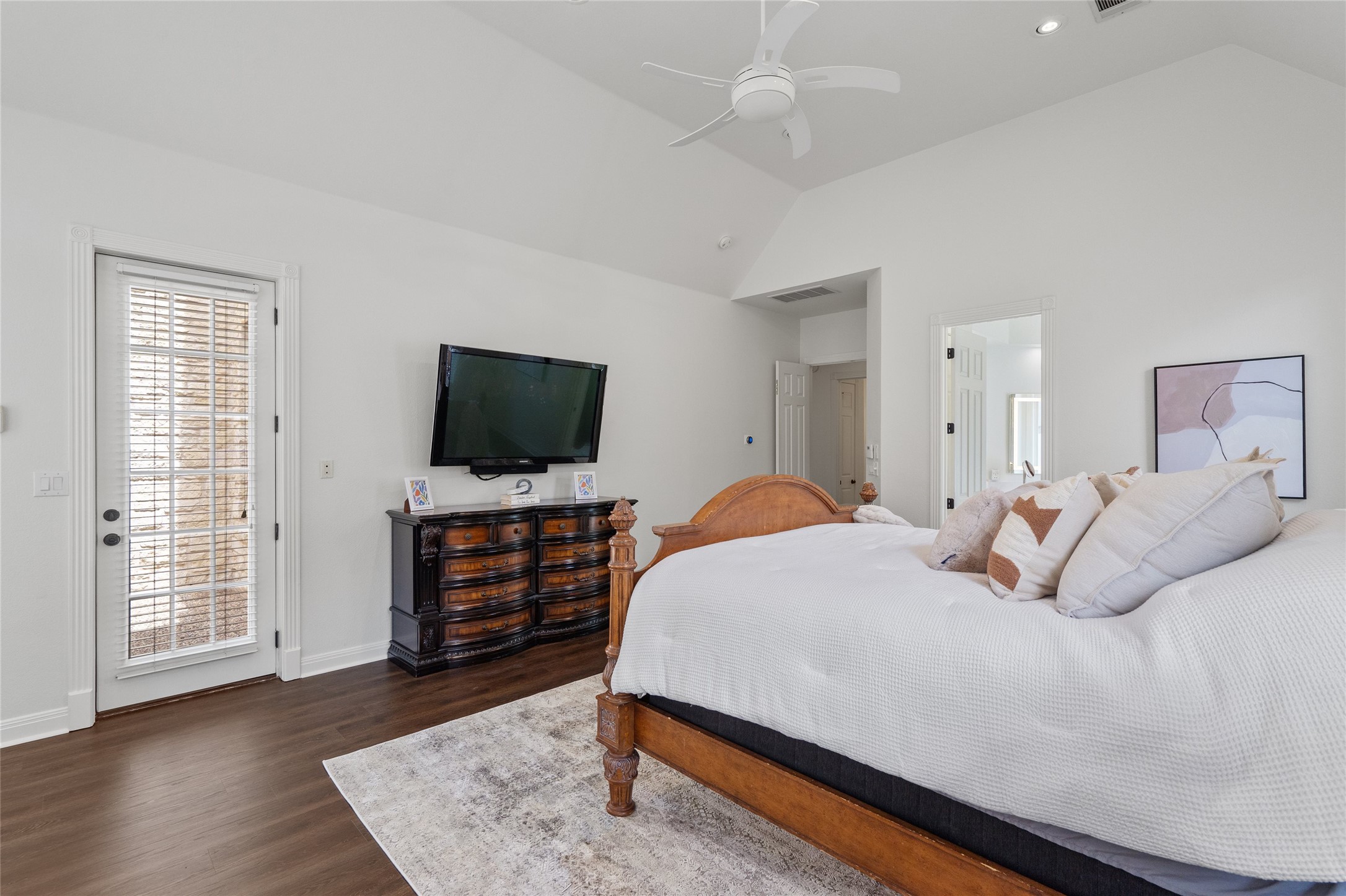 4313 Rio Robles Drive Austin, TX 78746 - Photo 20 of 40 Soaring vaulted ceilings elevate this primary bedroom with dark hardwood flooring and a ceiling fan.