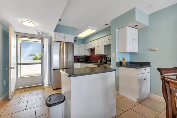 a kitchen with stainless steel appliances granite countertop a refrigerator a stove a sink and a microwave