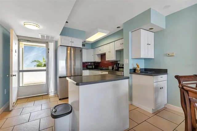 a kitchen with stainless steel appliances granite countertop a refrigerator a stove a sink and a microwave