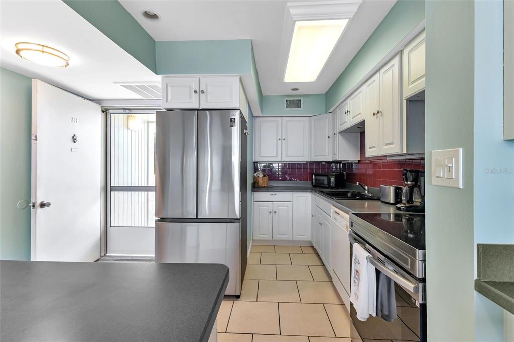1500 Park Beach Circle, Unit 3B Punta Gorda, FL 33950 - Photo 15 of 57 a kitchen with stainless steel appliances granite countertop a refrigerator a stove a sink and a microwave