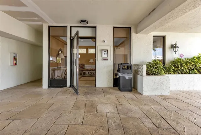 a living room with furniture a large window and stainless steel appliances