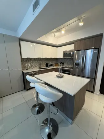 a kitchen with stainless steel appliances a sink a table and chairs