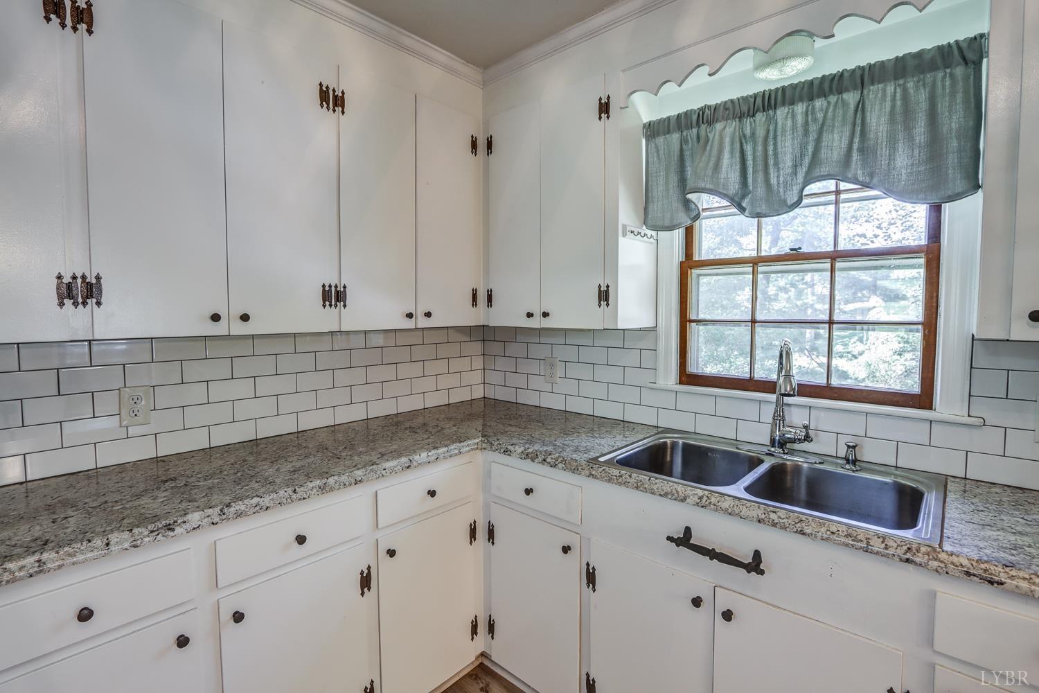 116 Bryant Road Lynchburg, VA 24502 - Photo 11 of 62 a kitchen with granite countertop a sink a window and white cabinets