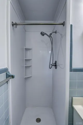 an empty room with wooden floor fireplace and windows