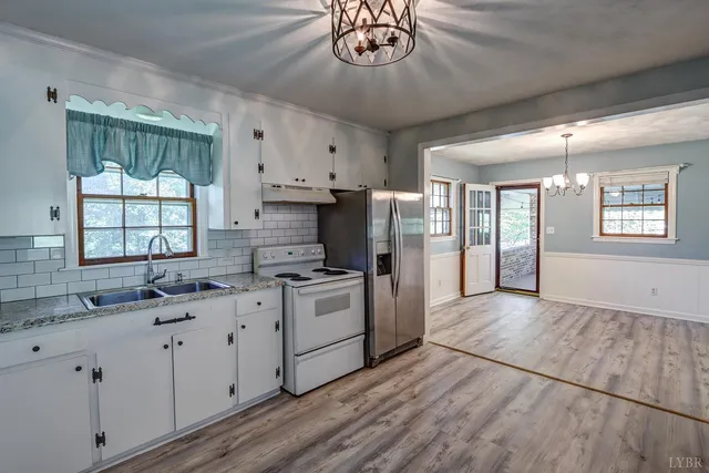 a kitchen with granite countertop white cabinets and stainless steel appliances
