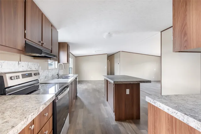 a kitchen with stainless steel appliances granite countertop a sink stove and refrigerator