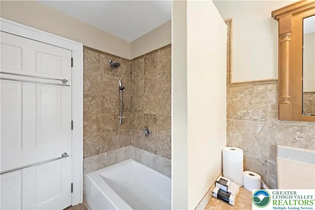 a bathroom with a tub shower and sink
