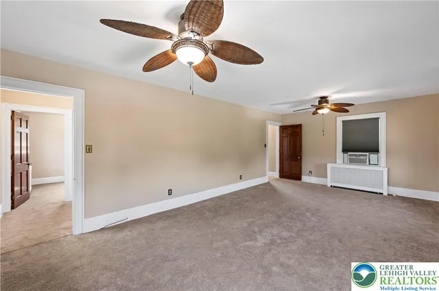 en empty room with windows and ceiling fan
