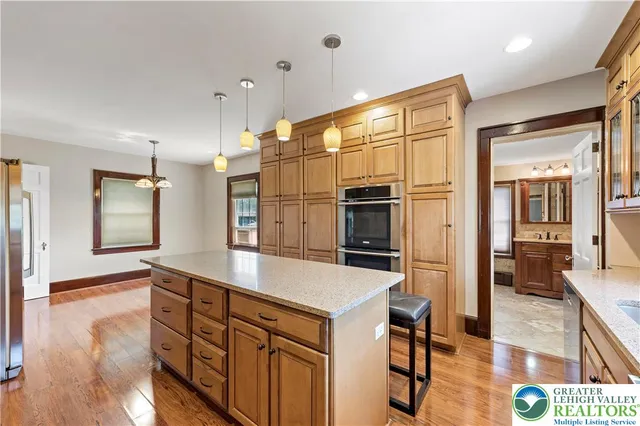 a large kitchen with kitchen island a large counter top and stainless steel appliances