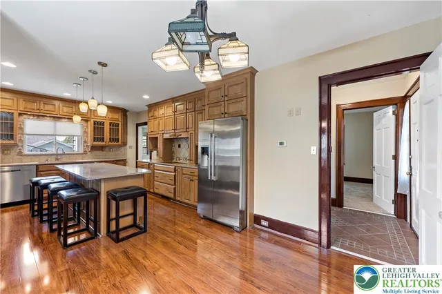 a dining room with wooden floor a chandelier a wooden table and chairs