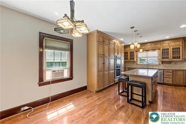 a room with chandelier fan and windows