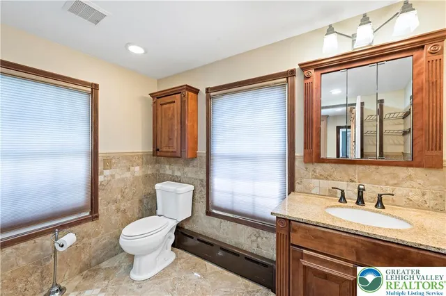 a bathroom with a granite countertop sink toilet and shower