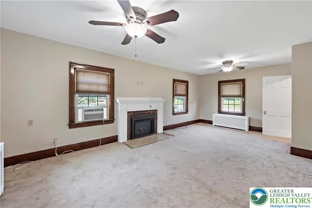 a view of an empty room with window and fireplace