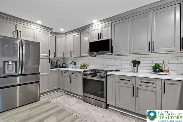 a kitchen with white cabinets stainless steel appliances and sink