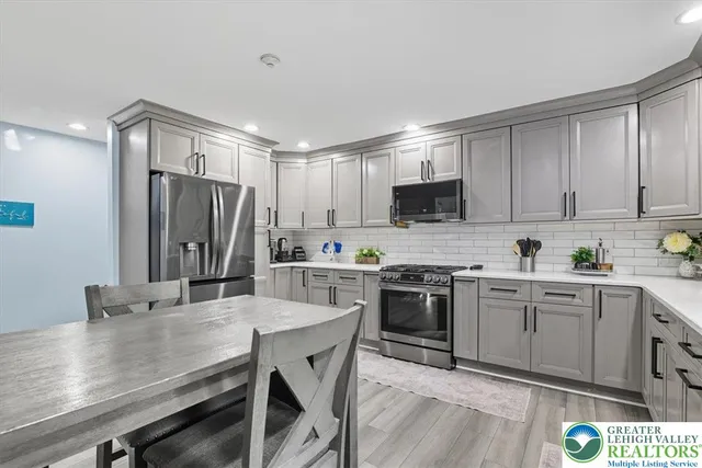a kitchen with stainless steel appliances granite countertop a stove refrigerator sink and cabinets