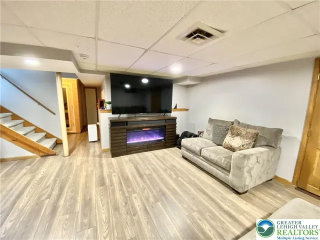 a living room with furniture a flat screen tv and a fireplace
