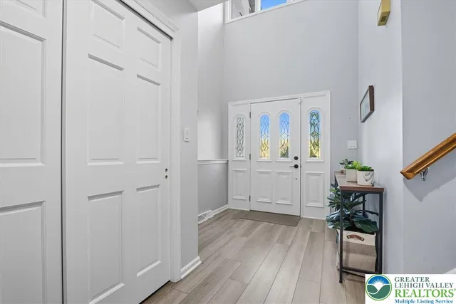a view of a hallway with wooden floor and a bathroom