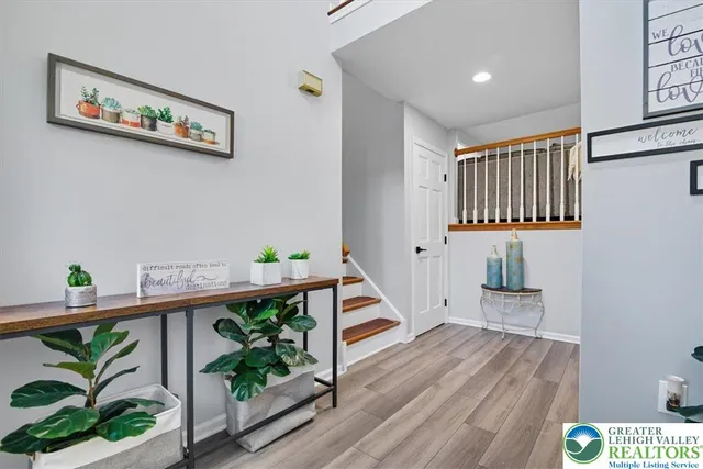 a view of a hallway with wooden floor and a potted plant