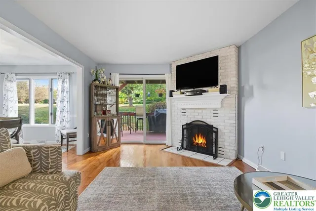 a living room with furniture a flat screen tv and a fireplace