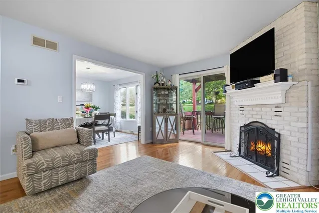 a living room with furniture a flat screen tv and a fireplace