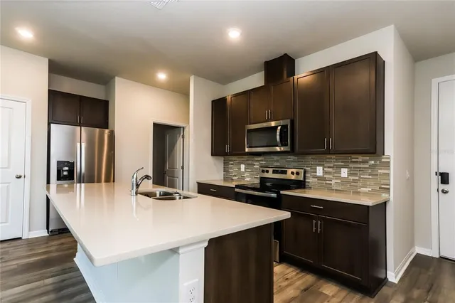 a kitchen with stainless steel appliances a microwave sink and refrigerator